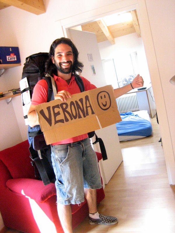 Yaniv with luggage and sign for Verona